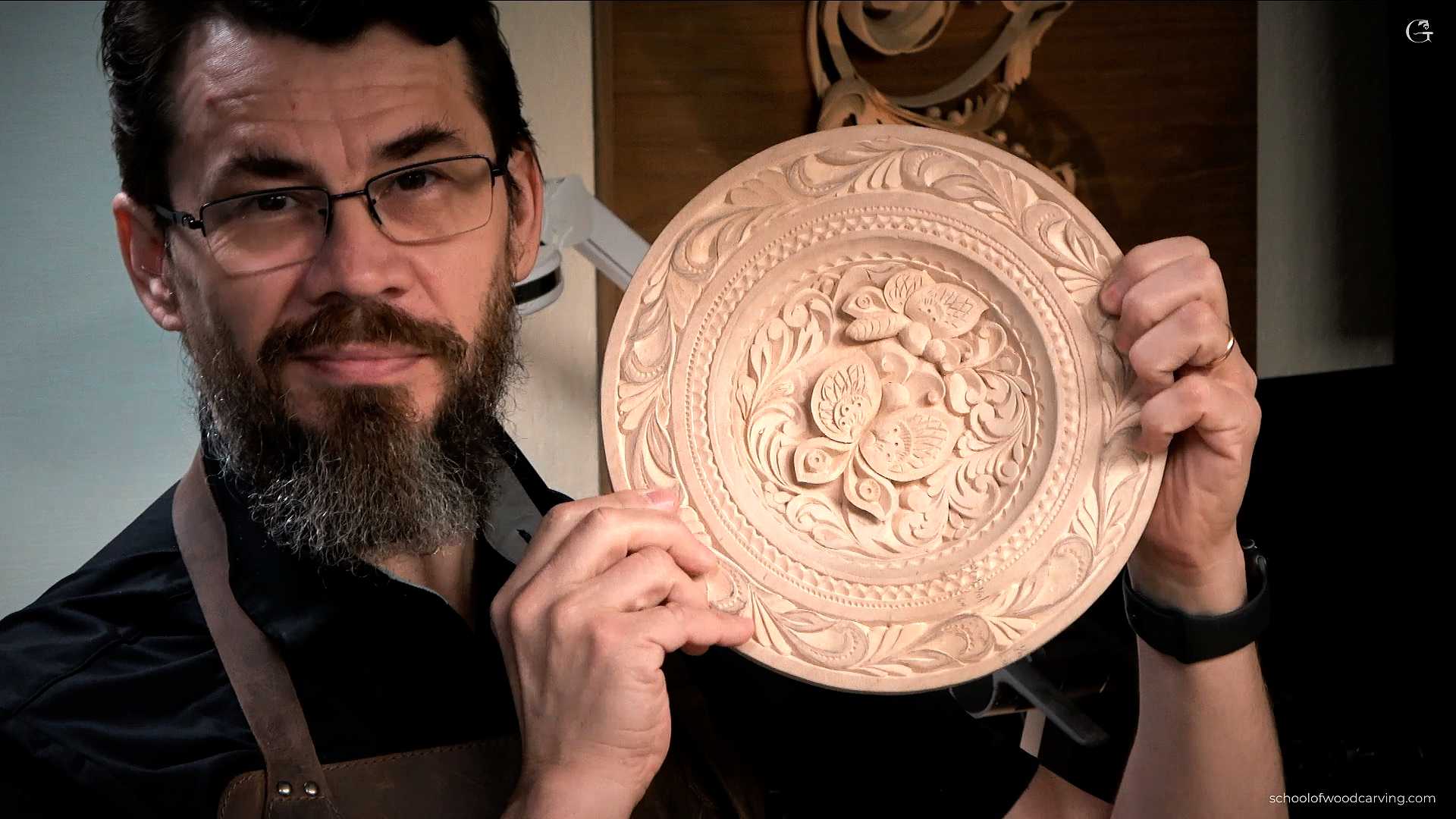 Alexander Grabovetskiy, a man with glasses and a gray beard, is holding a round piece of intricately carved wood featuring floral patterns. His impressive skills come from advanced woodcarving techniques, which he has mastered over many years. If you're interested in carving for beginners, there are many resources available to help you get started, including woodcarving lessons for beginners and woodcarving courses online. You can also find woodcarving tutorials step by step to guide you through various woodcarving projects for beginners. For those looking to improve, there are plenty of woodcarving tips and tricks available. Beginners should start with basic woodcarving tools for beginners, such as a good woodcarving knife and easy-to-follow woodcarving patterns for beginners. If you're looking for more hands-on guidance, search for woodcarving classes near me or attend woodcarving workshops. Woodcarving for seniors is also a great hobby, offering a relaxing and rewarding experience. Learning woodcarving knife techniques is crucial for precision and safety. Always follow woodcarving safety tips to avoid injuries. As you gain more confidence, try creating your own woodcarving designs easy enough to start but challenging enough to keep you engaged. You can find woodcarving kits for beginners that include all the essential tools and supplies. Understanding woodcarving basics is the first step towards creating unique pieces of woodcarving art. Invest in quality woodcarving tools and supplies to make your work easier and more enjoyable. Whether you're a beginner or looking to advance your skills, the world of woodcarving offers endless opportunities for creativity and craftsmanship.